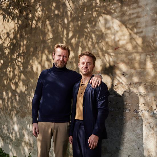 billede af to mænd der står foran en mur