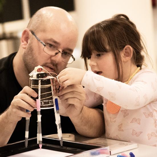 Far og datter bygger en kreativ robot
