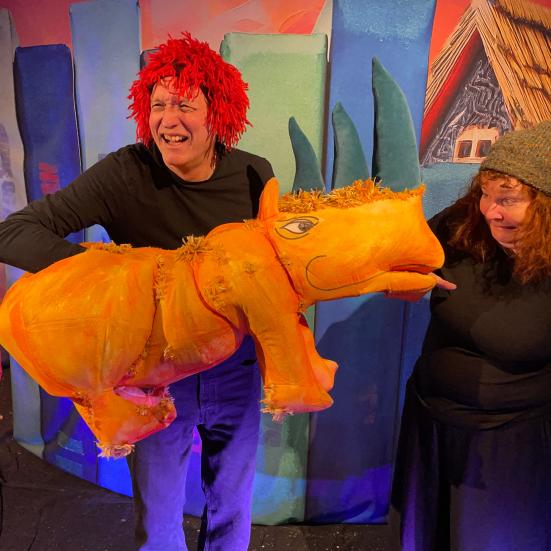 billede af en to mennesker med en gul næsehornsdukke