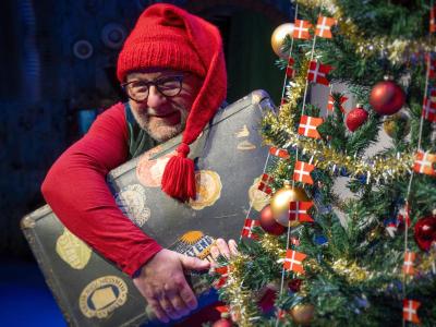 Nisse med kuffert ved siden af juletræ