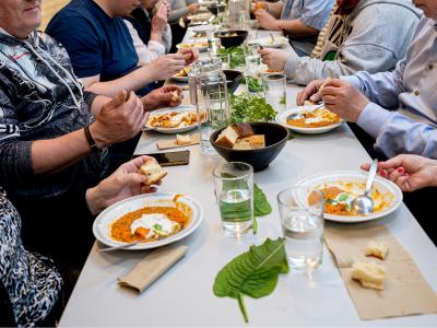 billede af bord dækket med mad og gæster bænket til spisning