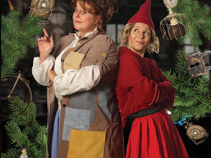 to kvinder udklædt som nisser står ryg mod ryg og smiler