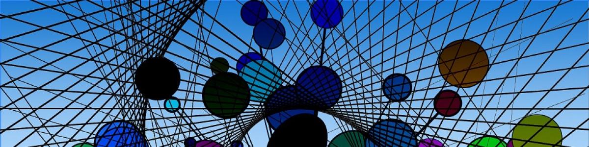 Et net udspænde op mod den blå himmel med påsatte glascirkler i strplende farver