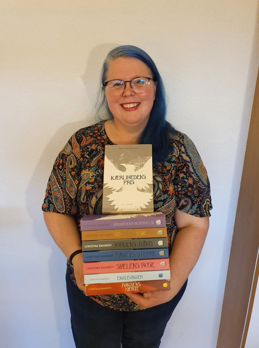 Billedet viser et portræt af forfatter Christina Ramskov der præsenterer sine bøger.