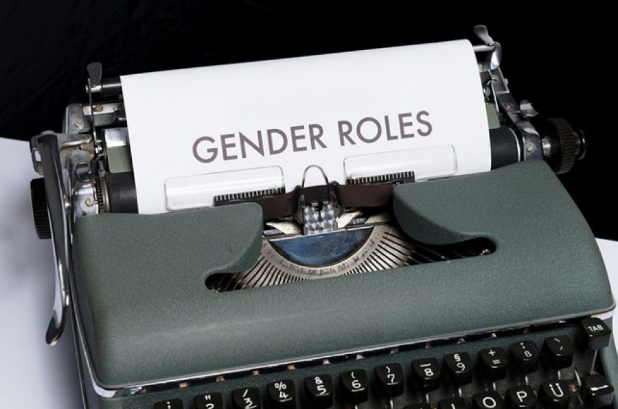 Gammel skrivemaskine med et stykke papir med ordet ”Gender roles”