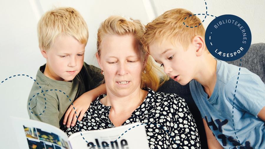 En kvinde sidder mellem to børn og læser højt